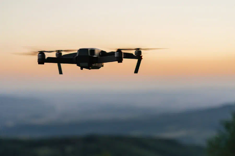 A reconnaissance drone in flight over hills at dusk